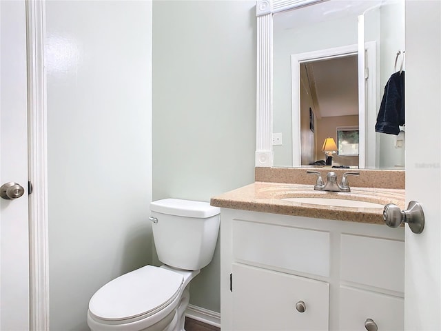 half bathroom featuring vanity and toilet