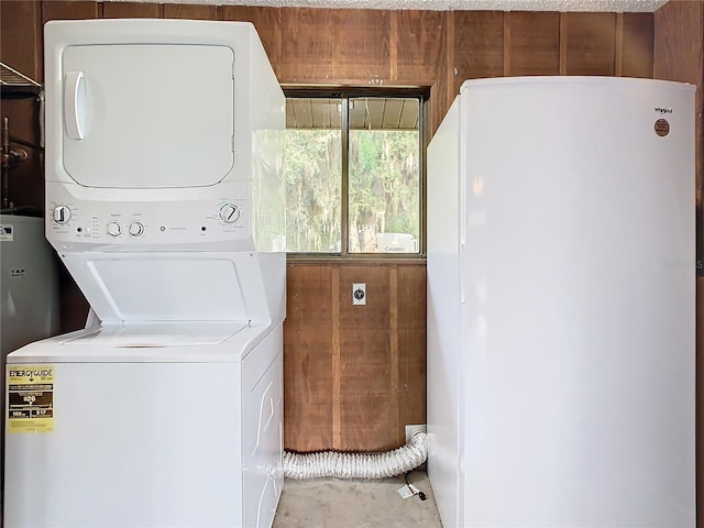 laundry room with laundry area, wooden walls, and stacked washer and clothes dryer