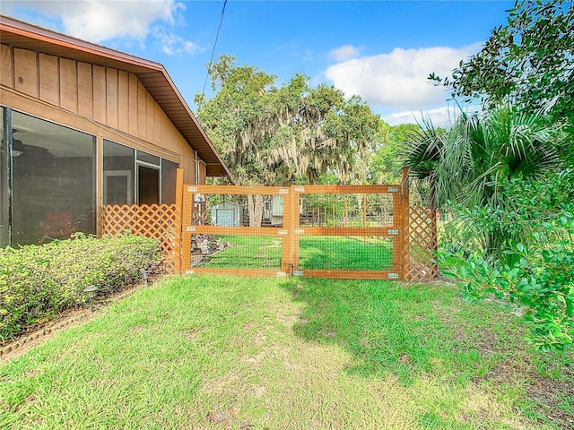 view of gate featuring a lawn and fence