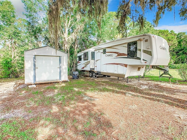 view of front of home featuring fence, an outdoor structure, and a storage unit