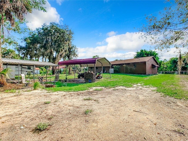 rear view of property with a lawn and a detached carport