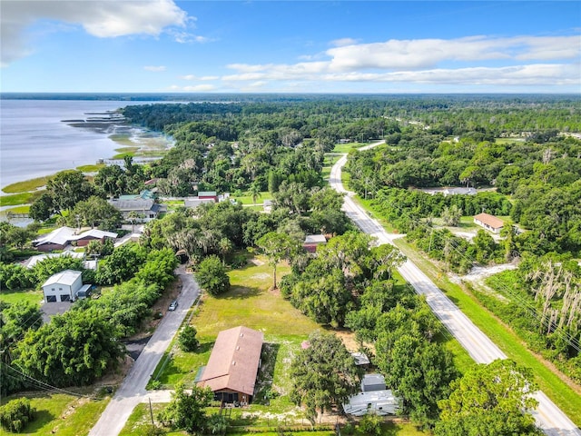 birds eye view of property with a water view and a wooded view