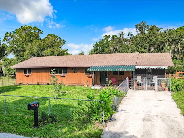 ranch-style home with concrete driveway, a carport, a front yard, and fence