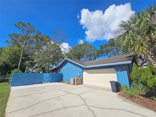 view of property exterior with central air condition unit and a garage