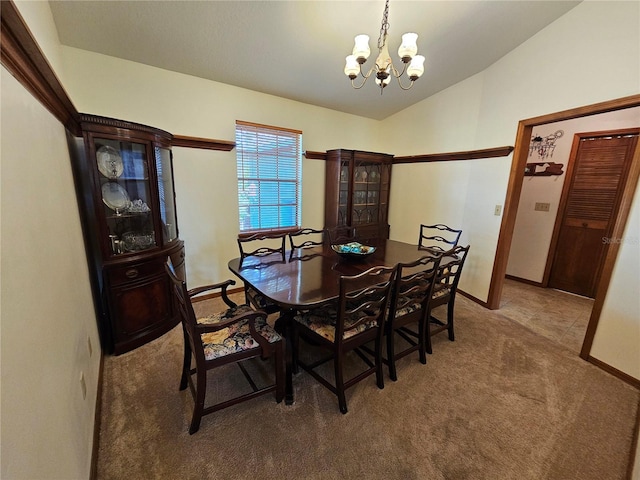 dining area featuring carpet, a chandelier, and vaulted ceiling