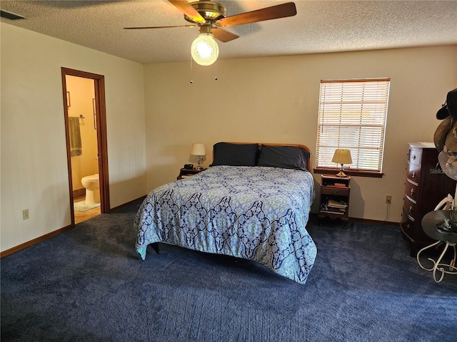 carpeted bedroom with a textured ceiling, ensuite bathroom, and ceiling fan