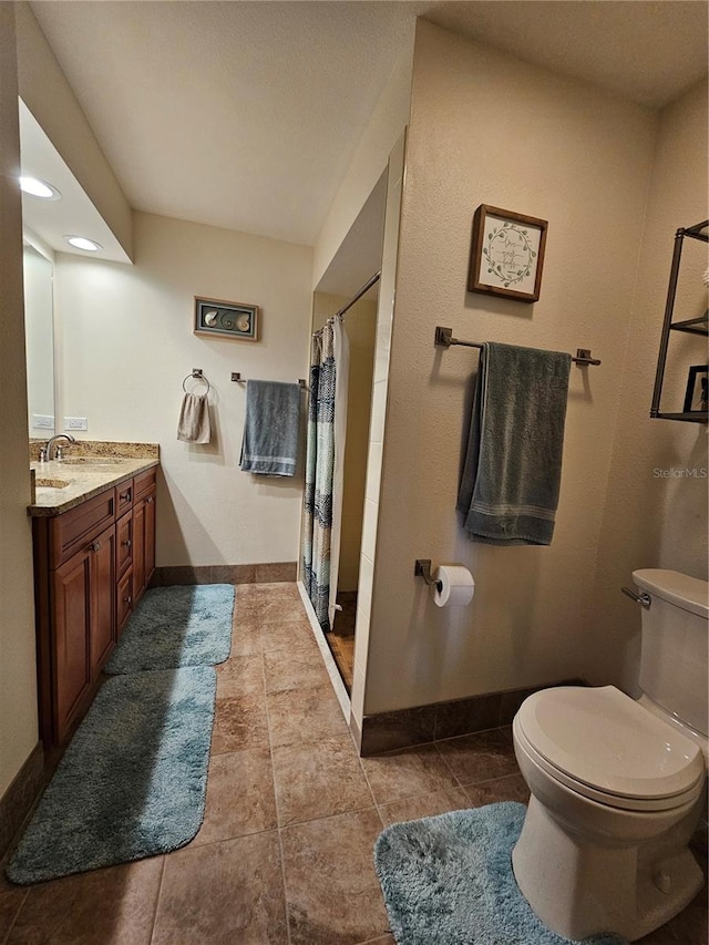 bathroom featuring vanity, toilet, tile patterned floors, and curtained shower