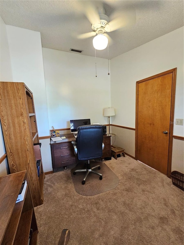 office space featuring ceiling fan, dark colored carpet, and a textured ceiling