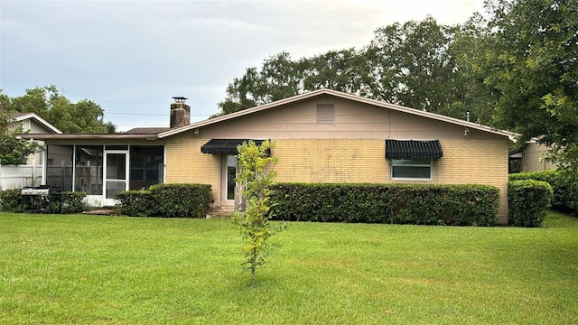 view of front of house featuring a sunroom and a front lawn