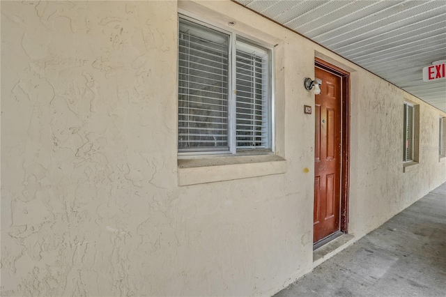 view of exterior entry featuring stucco siding