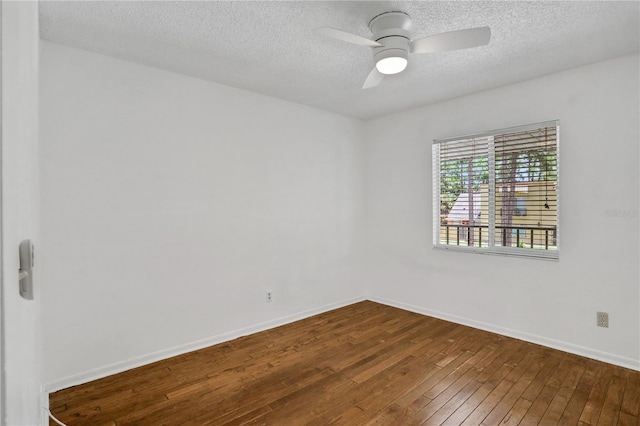 empty room featuring a textured ceiling, ceiling fan, wood finished floors, and baseboards