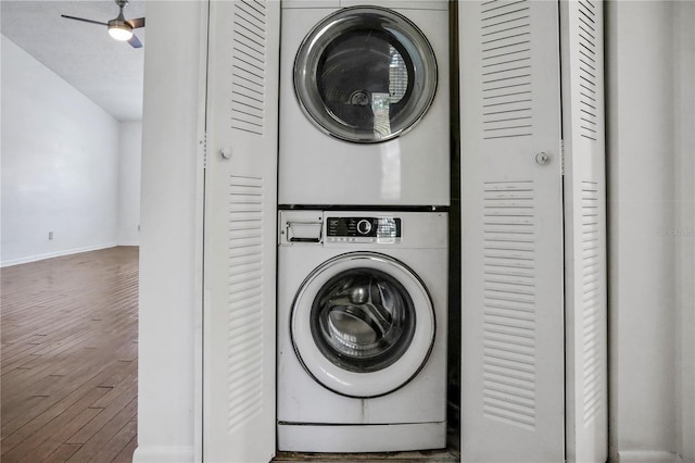 laundry room featuring stacked washer and dryer, laundry area, baseboards, a ceiling fan, and dark wood-style floors