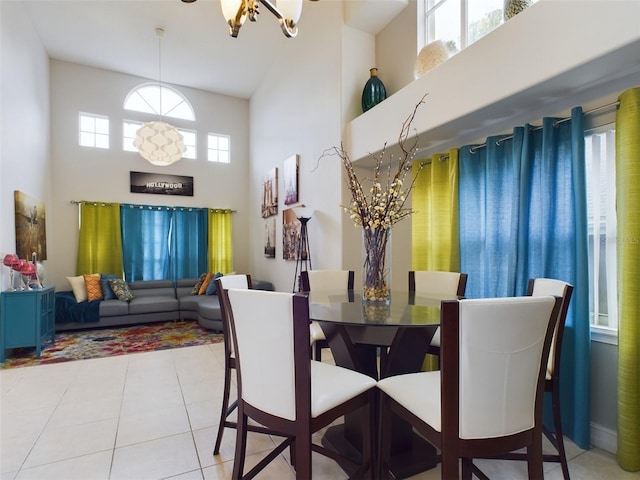 dining room featuring light tile patterned floors, a wealth of natural light, and a towering ceiling