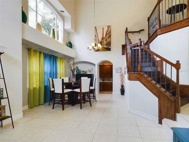 5219 Mystic Point Ct, Orlando, FL 32812 - tiled dining space featuring a high ceiling, arched walkways, stairway, and a chandelier