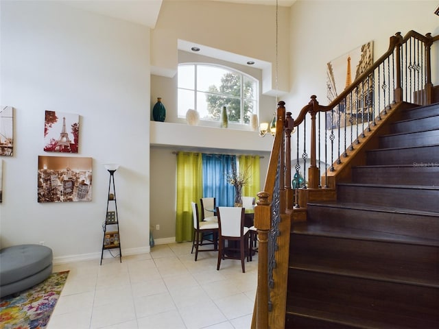 interior space with a notable chandelier, light tile patterned flooring, and high vaulted ceiling