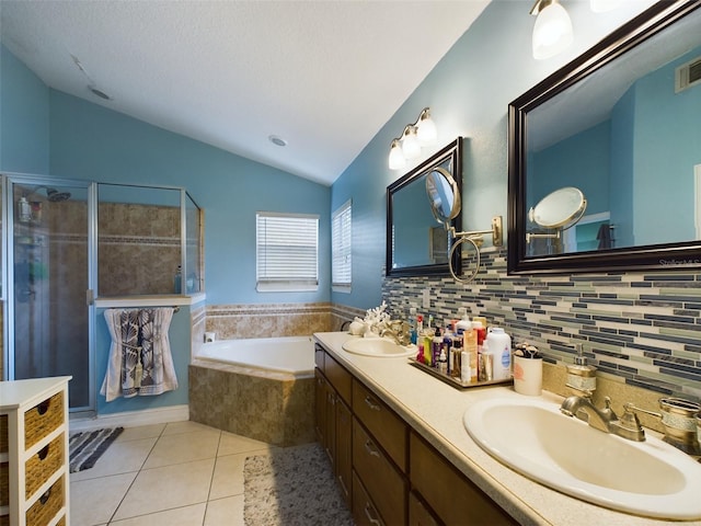 bathroom featuring independent shower and bath, vaulted ceiling, double sink vanity, tasteful backsplash, and tile patterned floors