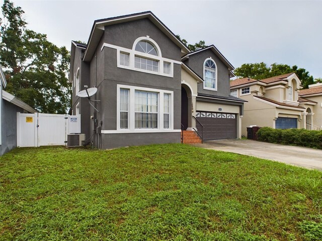5219 Mystic Point Ct, Orlando, FL 32812 - traditional-style home with a gate, driveway, an attached garage, a front lawn, and stucco siding