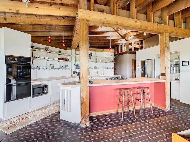 2741 Edwards Rd, Haines City, FL 33844 - kitchen featuring stainless steel appliances, brick flooring, and a kitchen bar