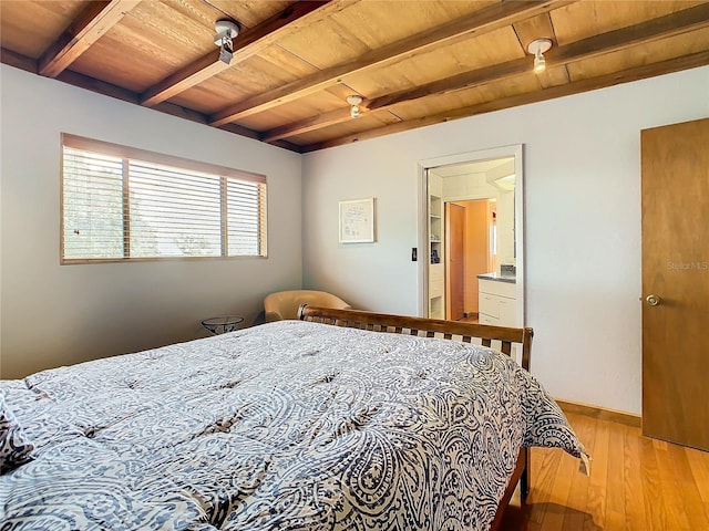 bedroom featuring beam ceiling, ensuite bathroom, light hardwood / wood-style flooring, and wooden ceiling