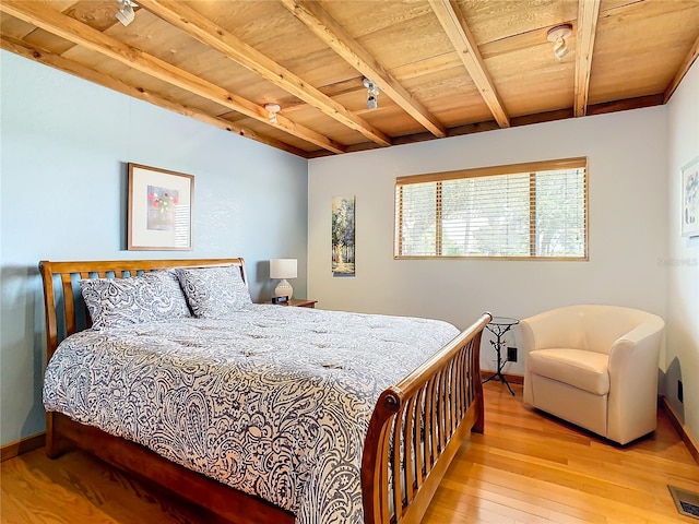 bedroom featuring wood ceiling, light hardwood / wood-style flooring, and beamed ceiling