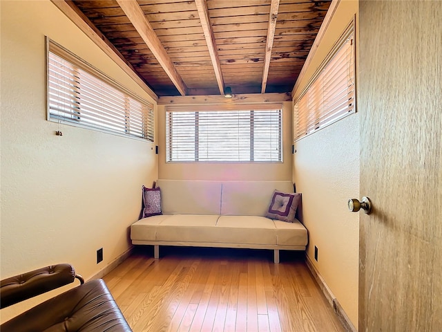 living area with beamed ceiling, light hardwood / wood-style floors, and wooden ceiling