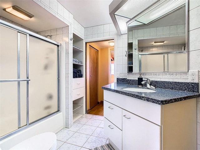 2741 Edwards Rd, Haines City, FL 33844 - bathroom with vanity, tile patterned flooring, combined bath / shower with glass door, and tile walls