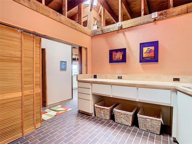 2741 Edwards Rd, Haines City, FL 33844 - kitchen with wooden ceiling, white cabinets, light countertops, and brick patterned floors