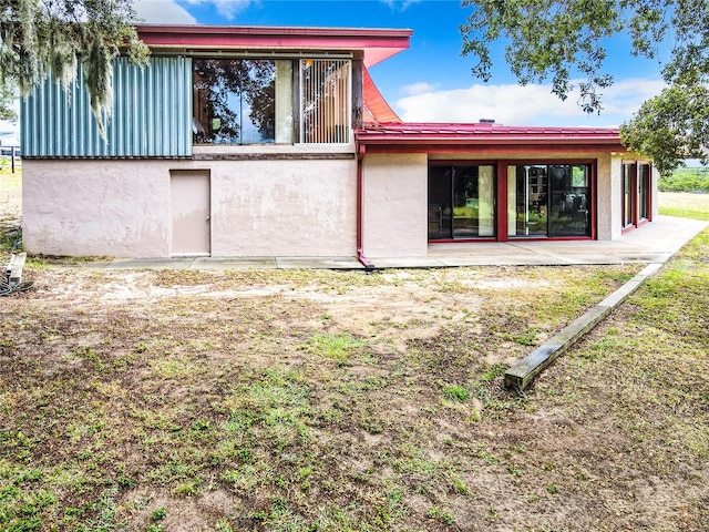 back of property with a patio and a lawn