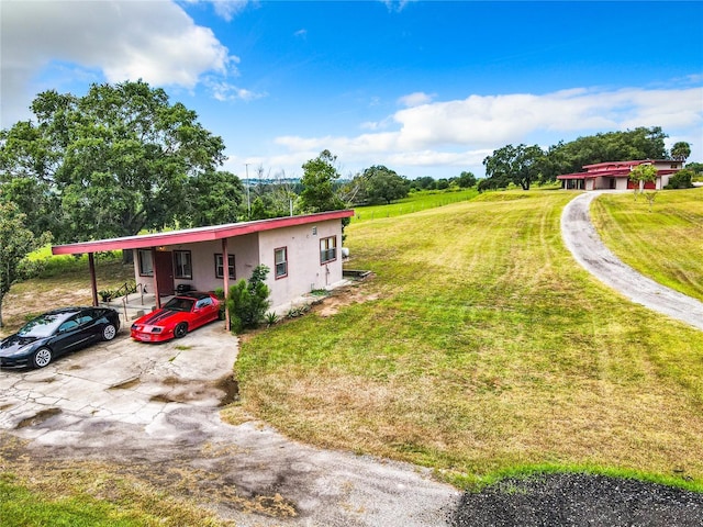 2741 Edwards Rd, Haines City, FL 33844 - view of front of house featuring a front yard, driveway, stucco siding, and an attached carport