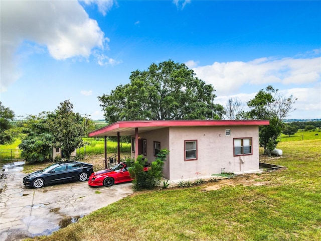 view of front of property featuring a carport and a front yard