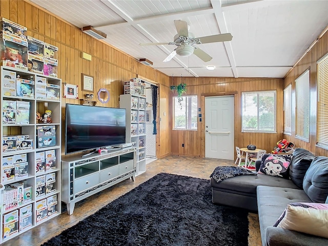 tiled living room with ceiling fan, coffered ceiling, and wood walls