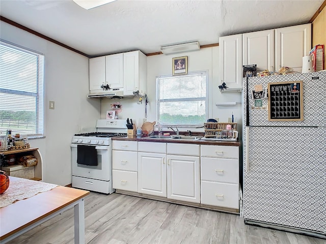 kitchen with white appliances, white cabinets, and a healthy amount of sunlight