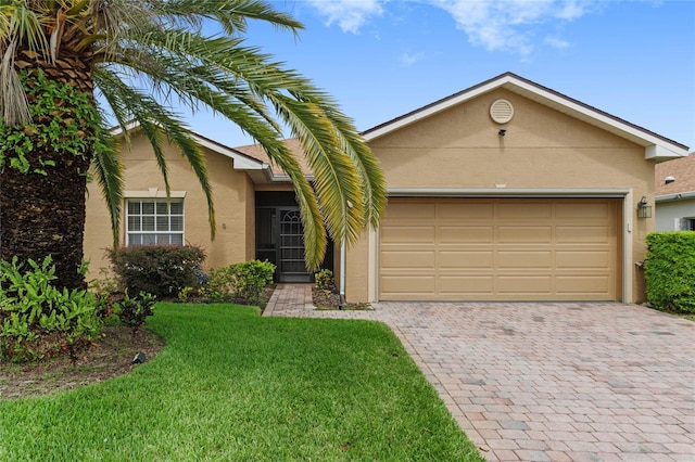 view of front of property with a front lawn, an attached garage, driveway, and stucco siding