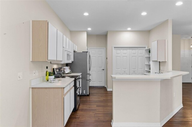 kitchen with double oven range, dark wood finished floors, recessed lighting, a peninsula, and white microwave