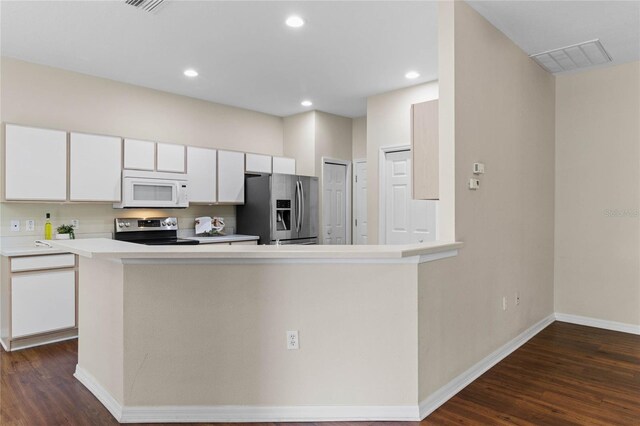 kitchen featuring stainless steel appliances, dark hardwood / wood-style floors, kitchen peninsula, and white cabinetry