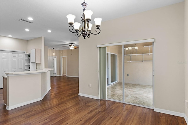 kitchen featuring dark wood-style floors, visible vents, light countertops, decorative light fixtures, and ceiling fan with notable chandelier