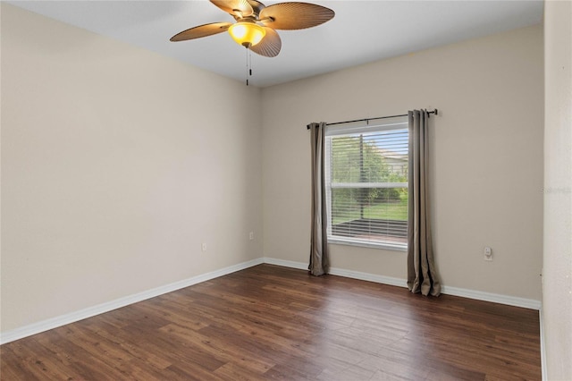 spare room with dark wood-style floors, ceiling fan, and baseboards