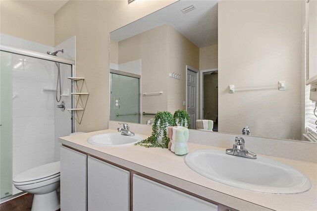 bathroom featuring vanity, toilet, hardwood / wood-style flooring, and a shower with shower door