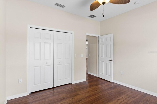 unfurnished bedroom featuring dark wood-type flooring, ceiling fan, and a closet