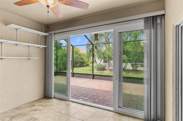 entryway with plenty of natural light, light tile patterned floors, and ceiling fan