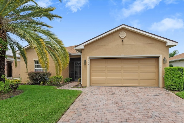 ranch-style house featuring stucco siding, decorative driveway, a garage, and a front yard
