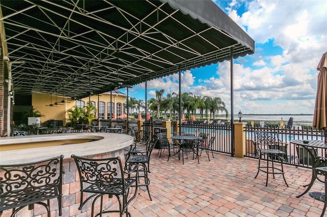 view of patio / terrace featuring a water view and fence