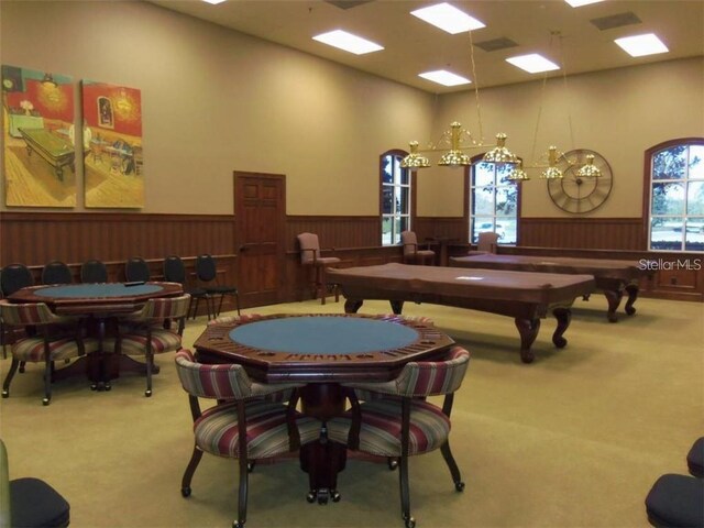 playroom featuring billiards, a high ceiling, wood walls, and light carpet