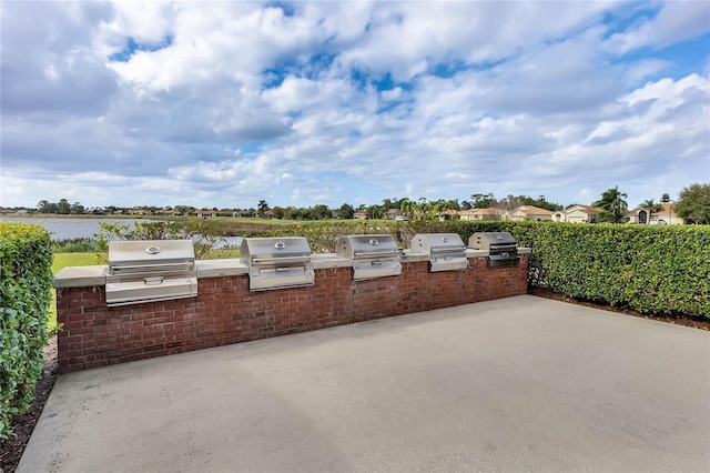 view of patio with exterior kitchen and a grill
