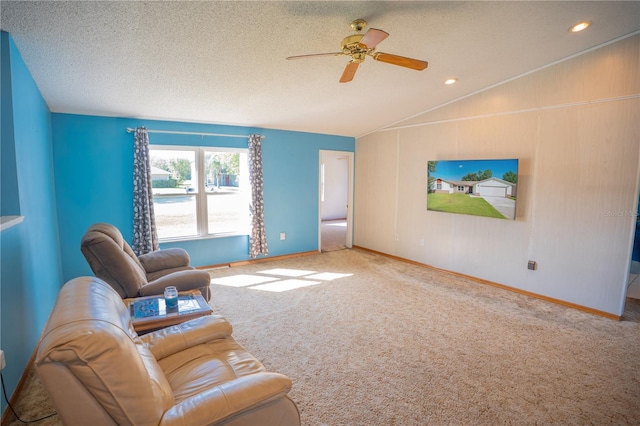 living room featuring ceiling fan, vaulted ceiling, a textured ceiling, and carpet flooring