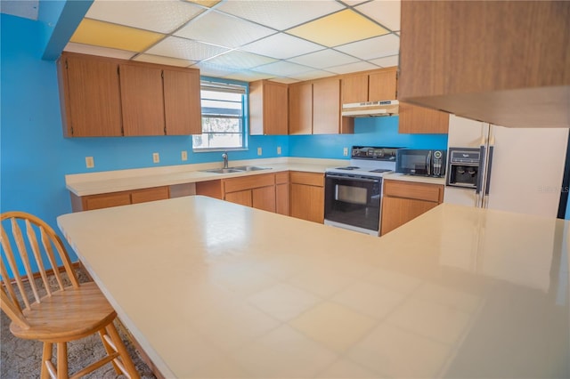 kitchen with sink, kitchen peninsula, a drop ceiling, and electric stove