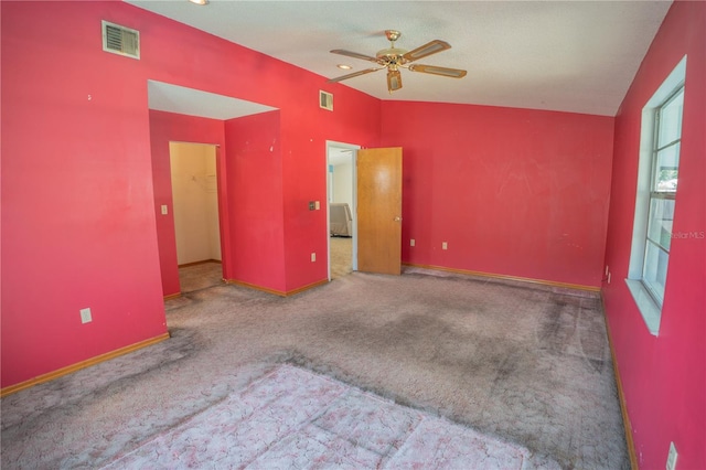 spare room with ceiling fan, lofted ceiling, and carpet flooring