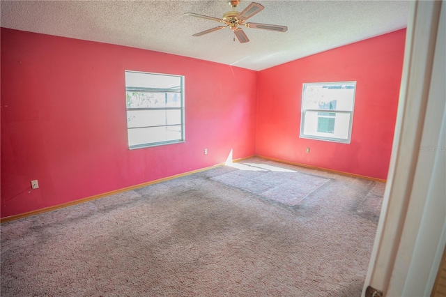 carpeted spare room with ceiling fan, a textured ceiling, and lofted ceiling