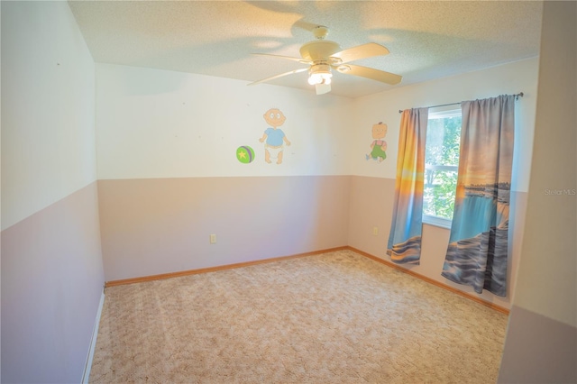 carpeted spare room with a textured ceiling and ceiling fan