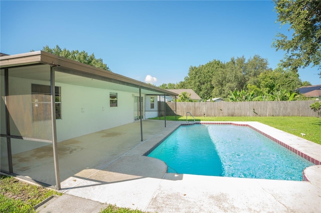 view of pool with a patio and a lawn